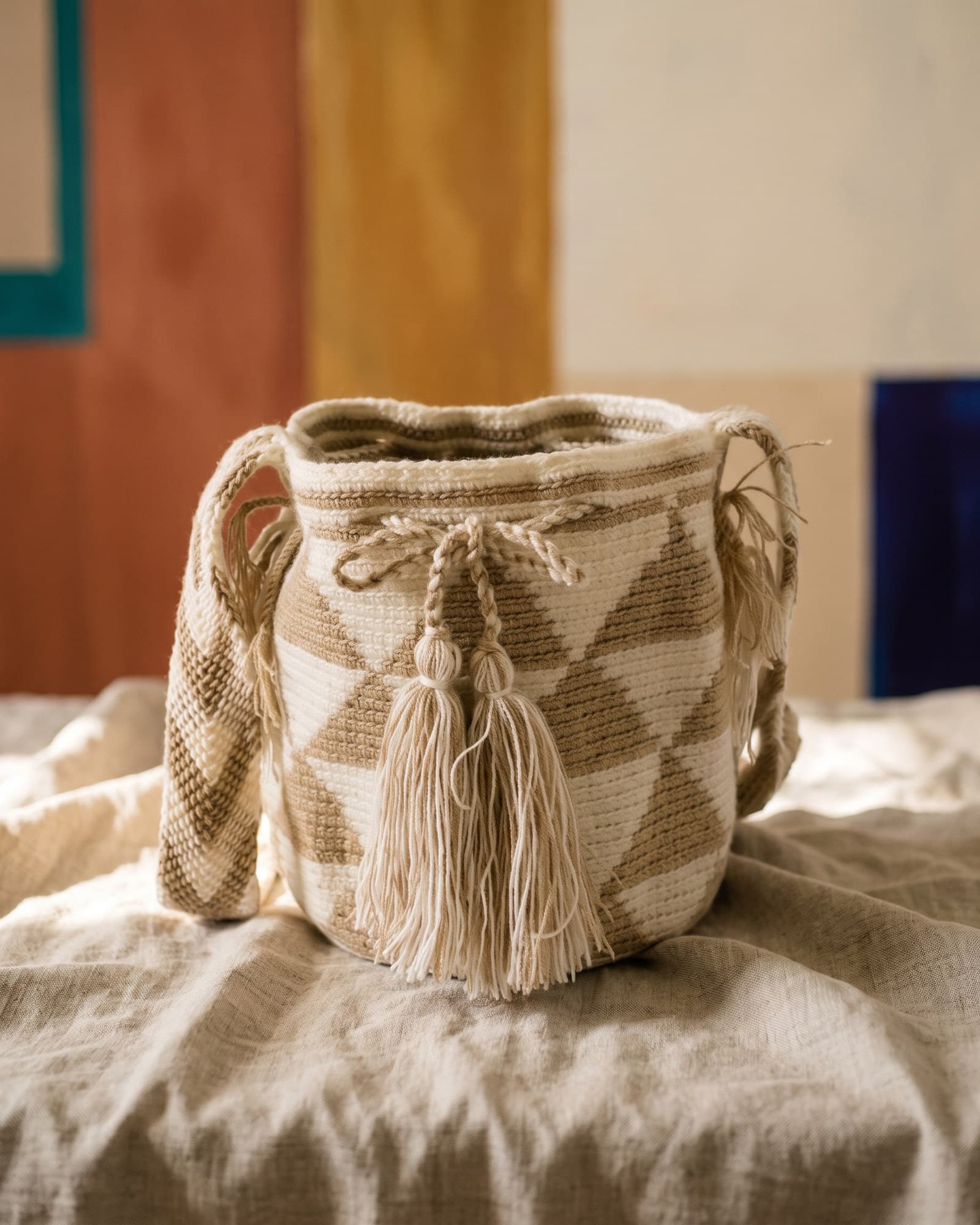 Mochila Rombos in Elfenbein und Sandbeige, auf Leinen ruhend im warmen Tageslicht.